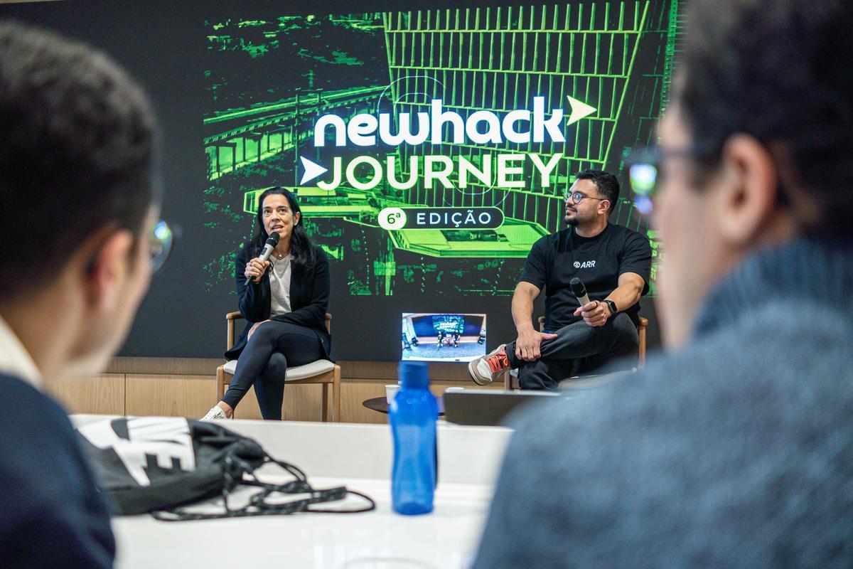 Painel com investidores no telão do NewHack Journey